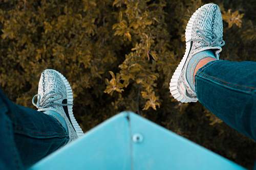 clothing person wearing white adidas sneakers sitting on blue steel frame footwear