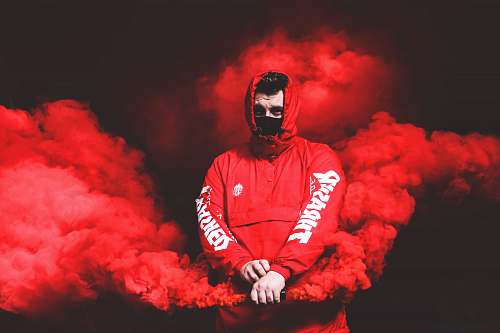 person man in red Thrasher pullover hooded jacket with red smoke human
