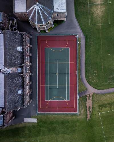 sportsfield aerial photo of green and red sports field tennis court