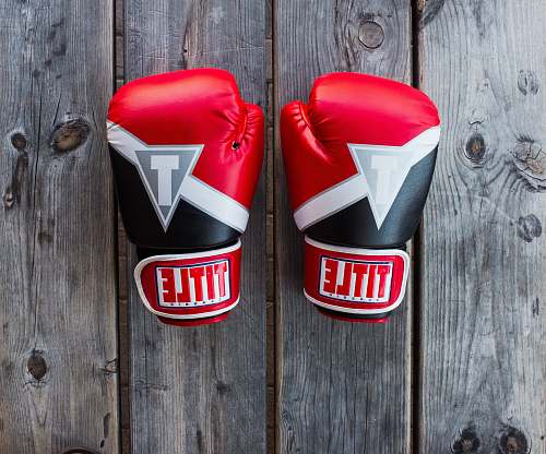 logo pair of red-and-black Title training gloves on grey wooden plank trademark