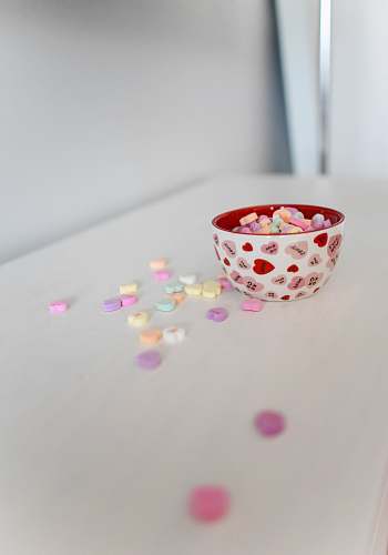 sweets white and red ceramic bowl on white surface candy