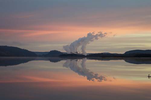 lake body of water under white clouds during orange sunset dusk