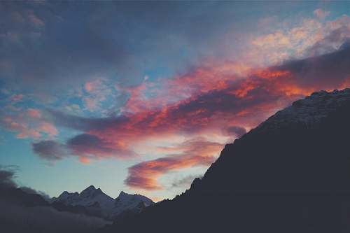 sky snow capped mountain under red clouds and blue sky dusk