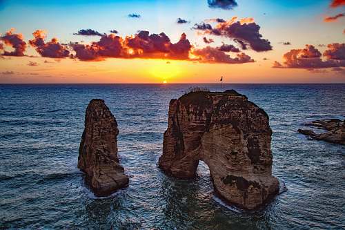 sky two rock formations in body of water beirut