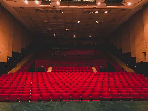 hall landscape photography of red seats inside a theater indoors