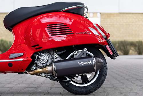 vehicle red motor scooter parked on brick floor motorcycle