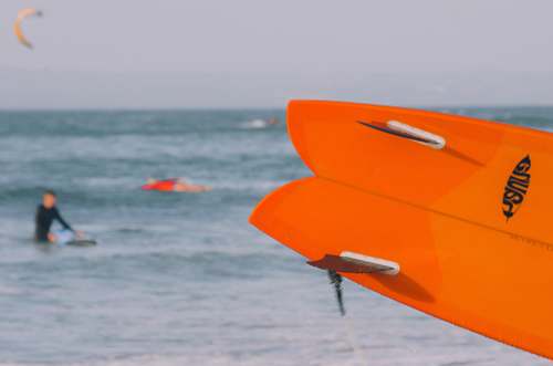 person close-up photo of orange surfboard human