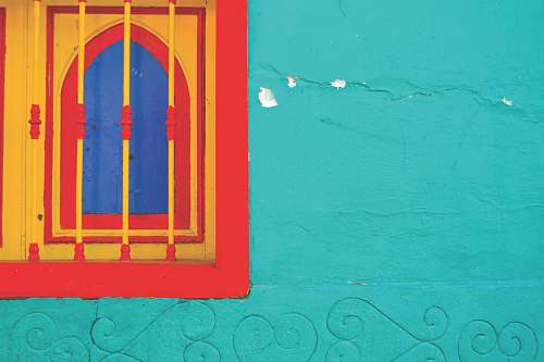 window yellow and red window along on green painted wall blue