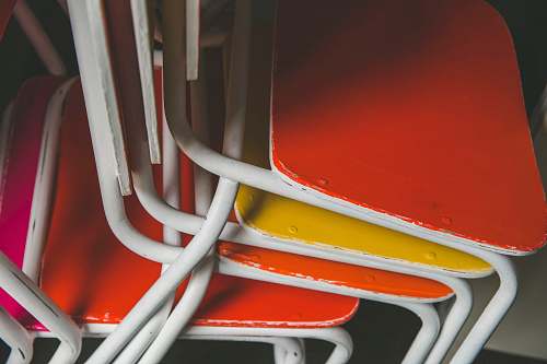 red stacked of orange and yellow metal chairs chairs