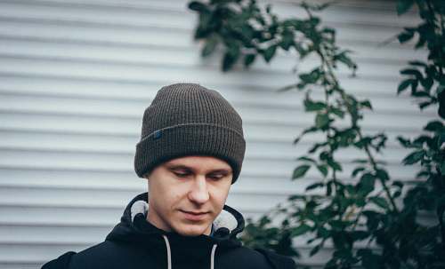 beanie man standing near green plant cap