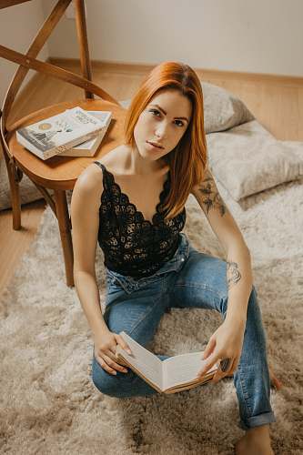 people woman holding book leaning on wooden chair person