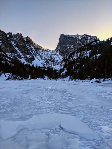 nature glacier mountains beside trees and snowfield during day ice