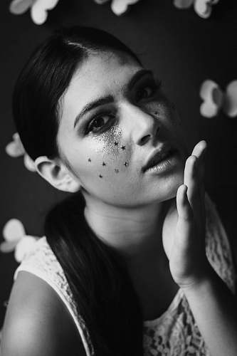 black-and-white Black and white shot of attractive woman with dark hair and face glitter portrait
