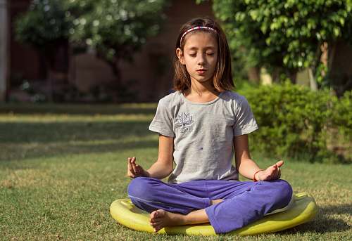 person girl performing meditation on yellow seat outdoors yoga