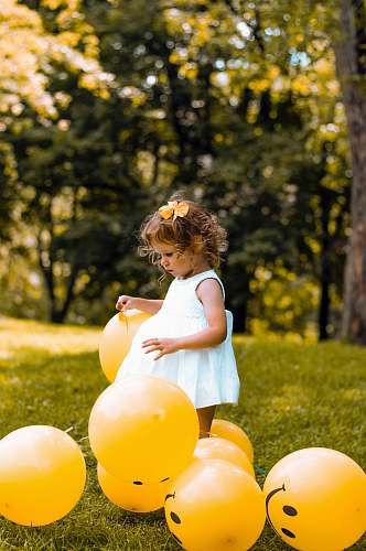 person girl wearing white sleeveless dress beside balloons human