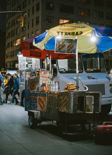 person gray food stall with umbrella near vehicle human