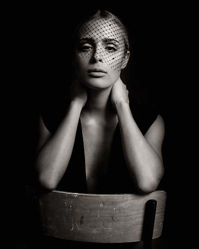 human grayscale photo of woman sitting on chair person
