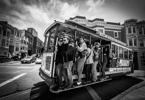 person grayscale photography of group of person riding on vehicle black-and-white