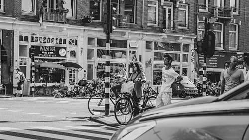 black-and-white grayscale photography of people walking across street bicycle