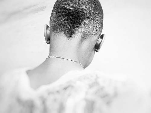 person grayscale photography of person wearing necklace black-and-white
