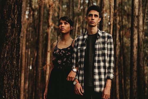 human man and woman standing next to another in forest person