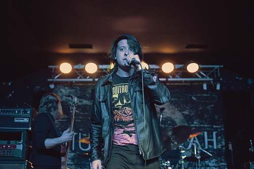 person man in black leather jacket singing with microphone human