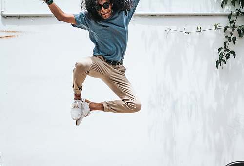 human man jump on front of wall plant