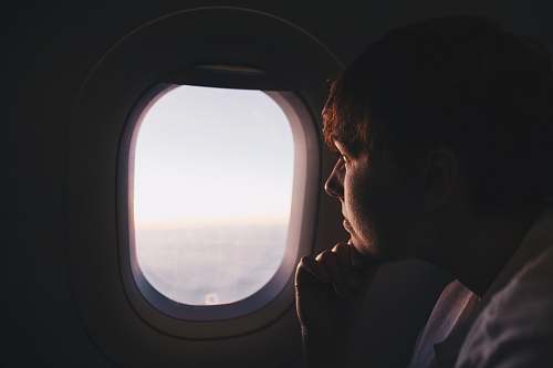 person man looking at window inside plane window