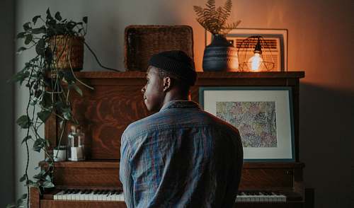 person man sitting at the piano plant