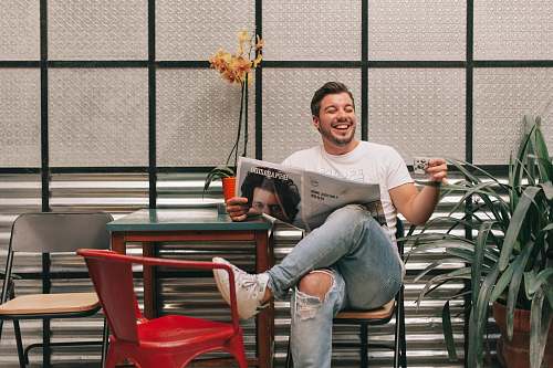 human man sitting beside red plastic chair person