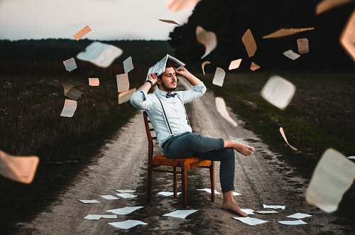human man sitting on chair with book chair
