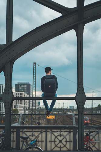 bike man sitting on top of bridge human