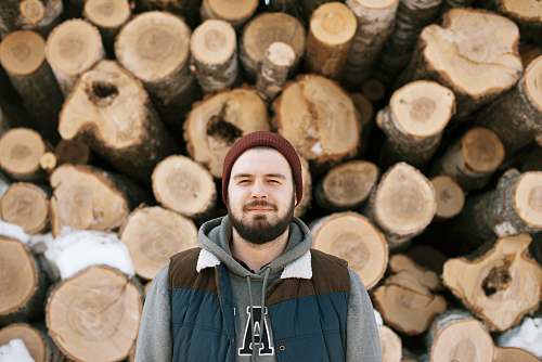 wood man standing behind firewoods lumber