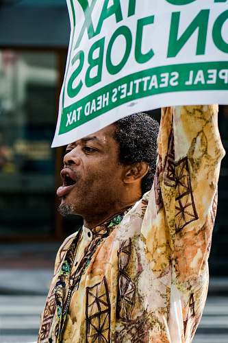 human man standing holding signage shouting person