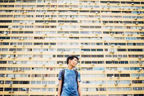 person man standing in front of skyscraper human