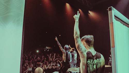 human man wearing black sleeveless shirt with tattoo's on the concert person