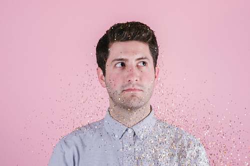 human man wearing gray polo shirt behind pink background close-up photo person