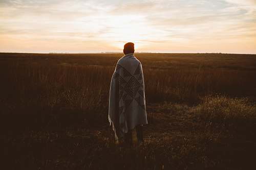 human person cover in robe standing in front of grass field person