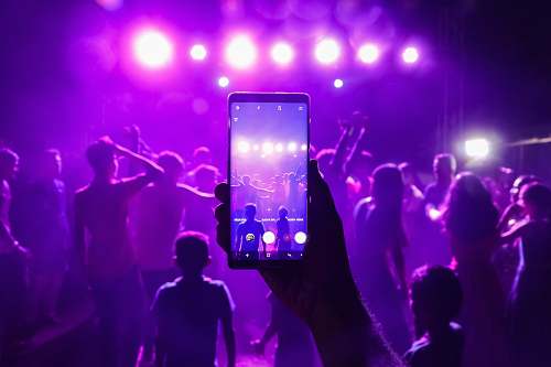 human person holding smartphone taking photos inside bar person