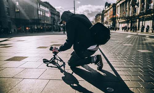 person person kneeling on floor taking photo with sunlight human