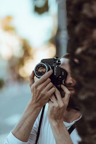 human person using black Nikon DSLR camera camera
