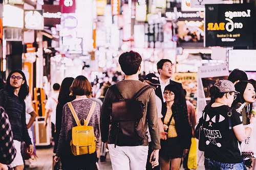 human photography of man wearing brown backpack near lounge on 6 bar person