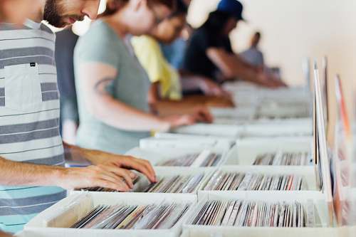 person selective focus photography of group of people selecting vinyl record sleeves human