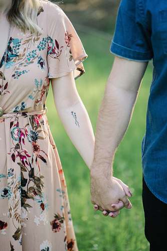 human selective focus photography of man and woman holding there hands person