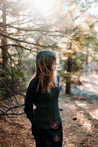 person selective focus photography of woman standing beside tree human