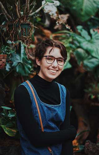 human selective focus photography of woman standing in front of plants person