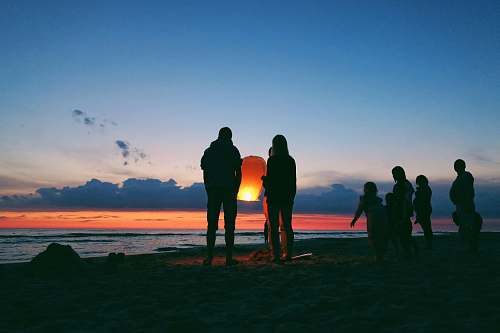 person silhouette of person holding sky lantern human