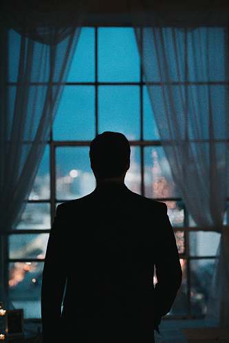 person silhouette of person standing against windowpane human
