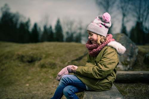 human smiling girl sitting on brown bench person