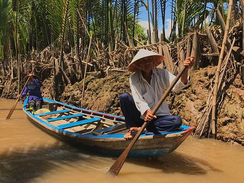 person two men riding canoe on bridge boat